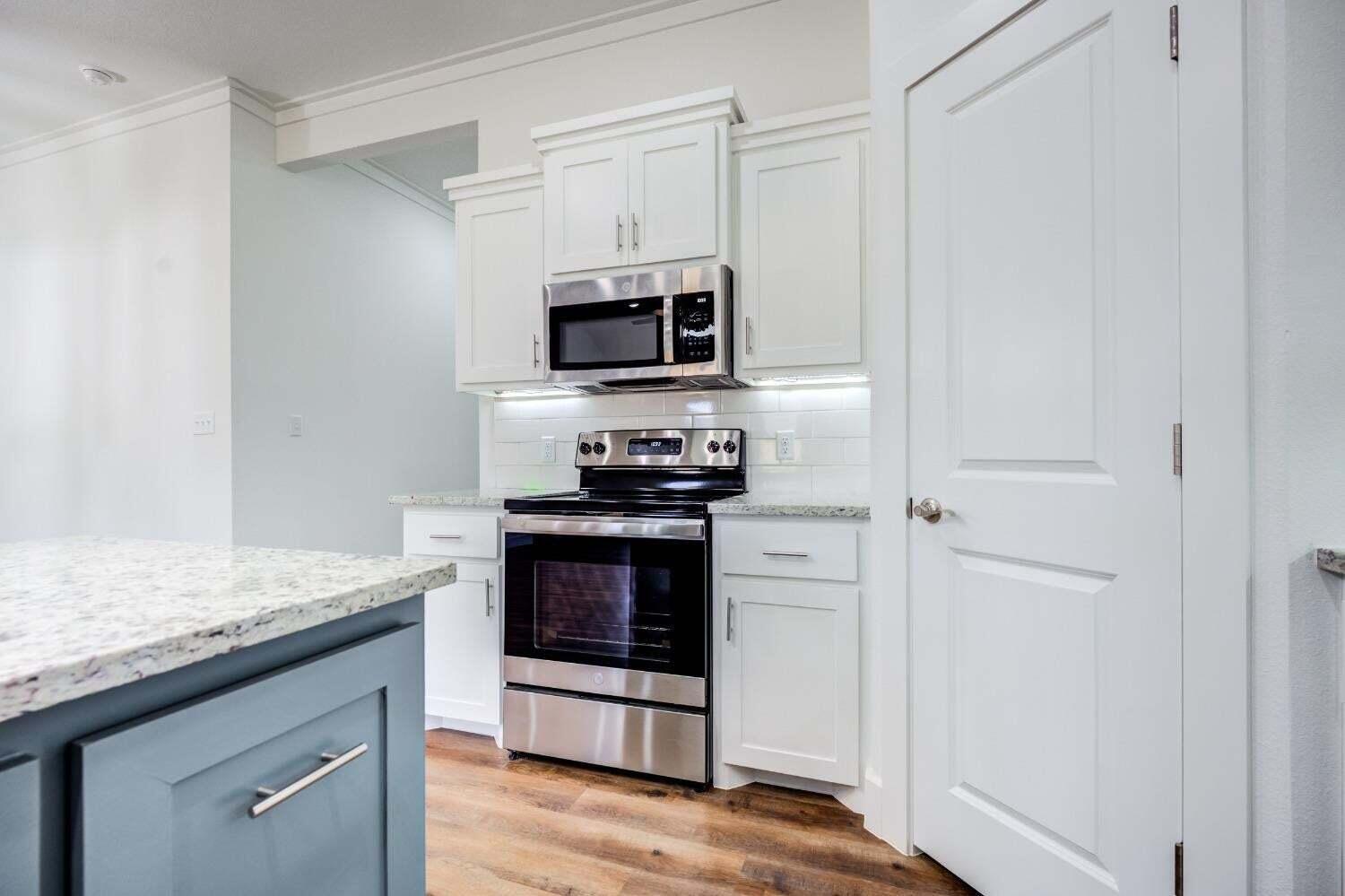 7808 97th Street Lubbock, TX 79424 - Photo 16 of 38 a kitchen with stainless steel appliances granite countertop a stove microwave and sink