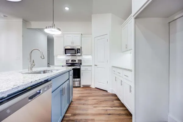 a kitchen with stainless steel appliances granite countertop a stove top oven a sink and dishwasher