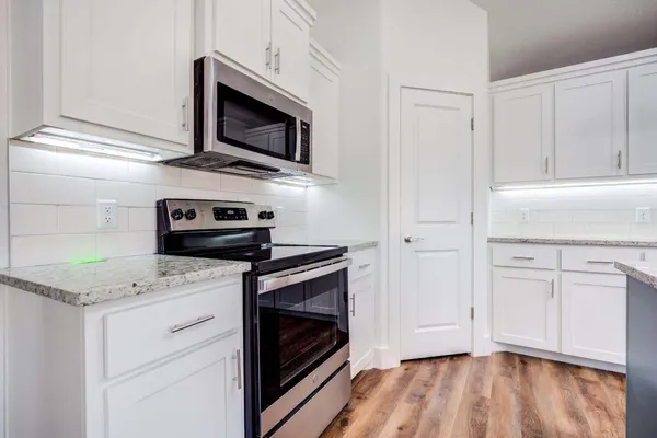 a kitchen with stainless steel appliances granite countertop a stove microwave and sink