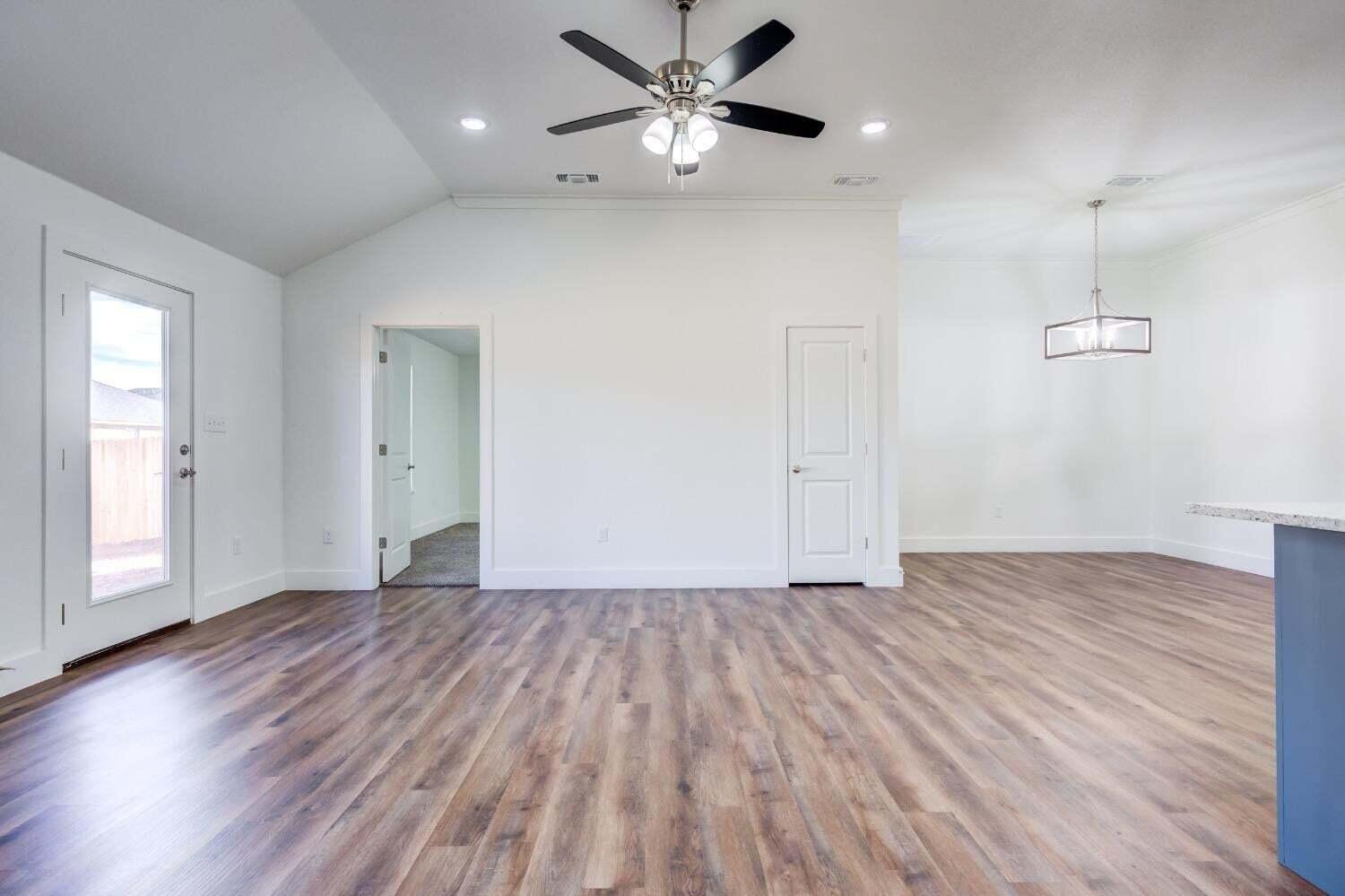 7808 97th Street Lubbock, TX 79424 - Photo 29 of 38 a view of an empty room with window and wooden floor