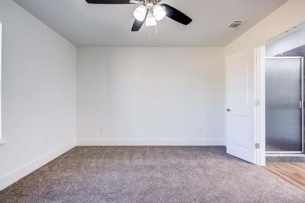 an empty room with a chandelier fan