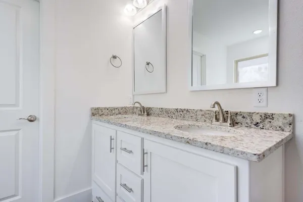 a bathroom with a granite countertop sink and a mirror
