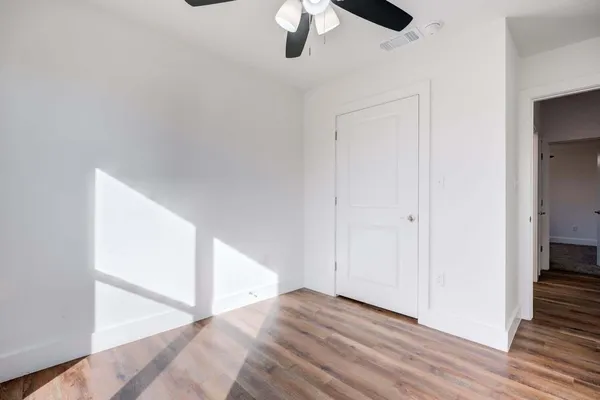 a view of an empty room with wooden floor