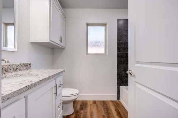 a bathroom with a granite countertop sink toilet and shower