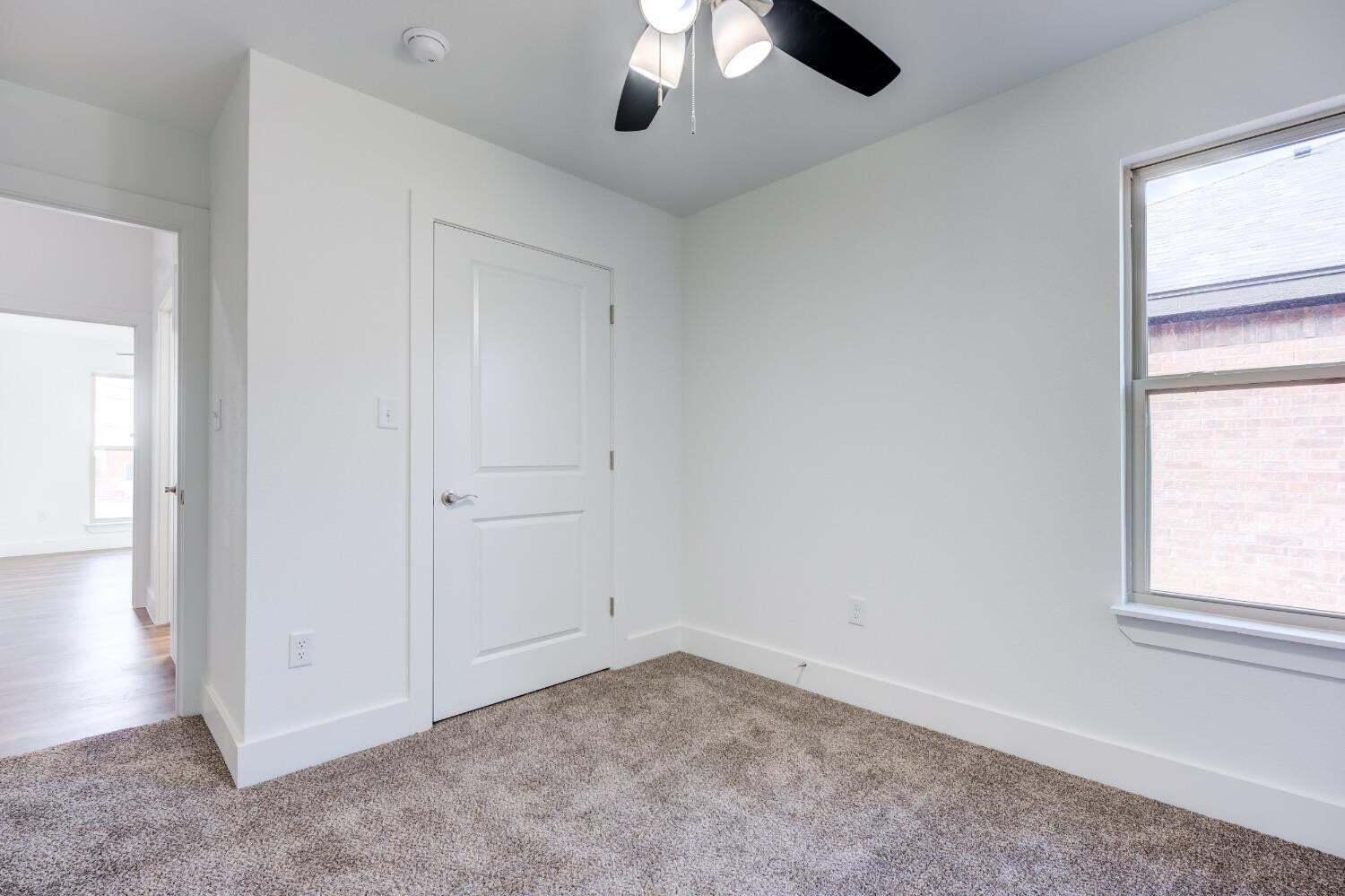7808 97th Street Lubbock, TX 79424 - Photo 9 of 38 an empty room with chandelier fan and windows