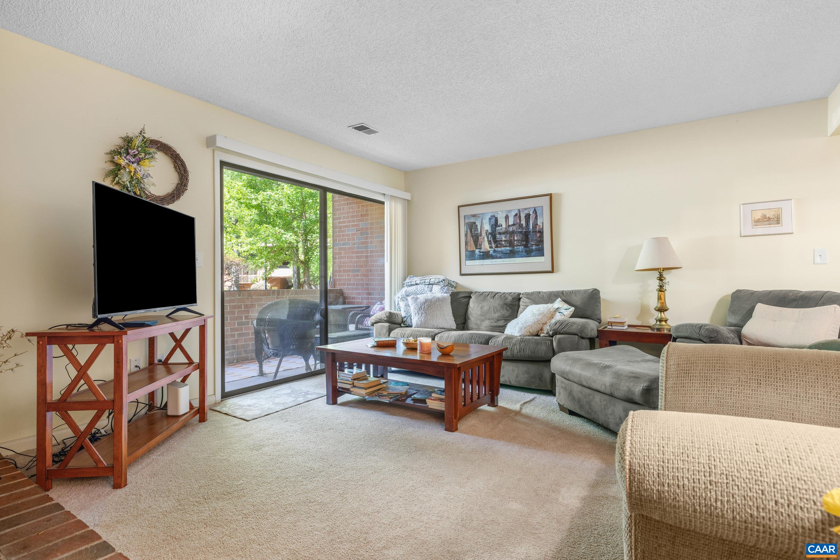 103 Turtle Creek Road, Unit 1 Charlottesville, VA 22901 - Photo 4 of 24 a living room with furniture flat screen tv and a large window