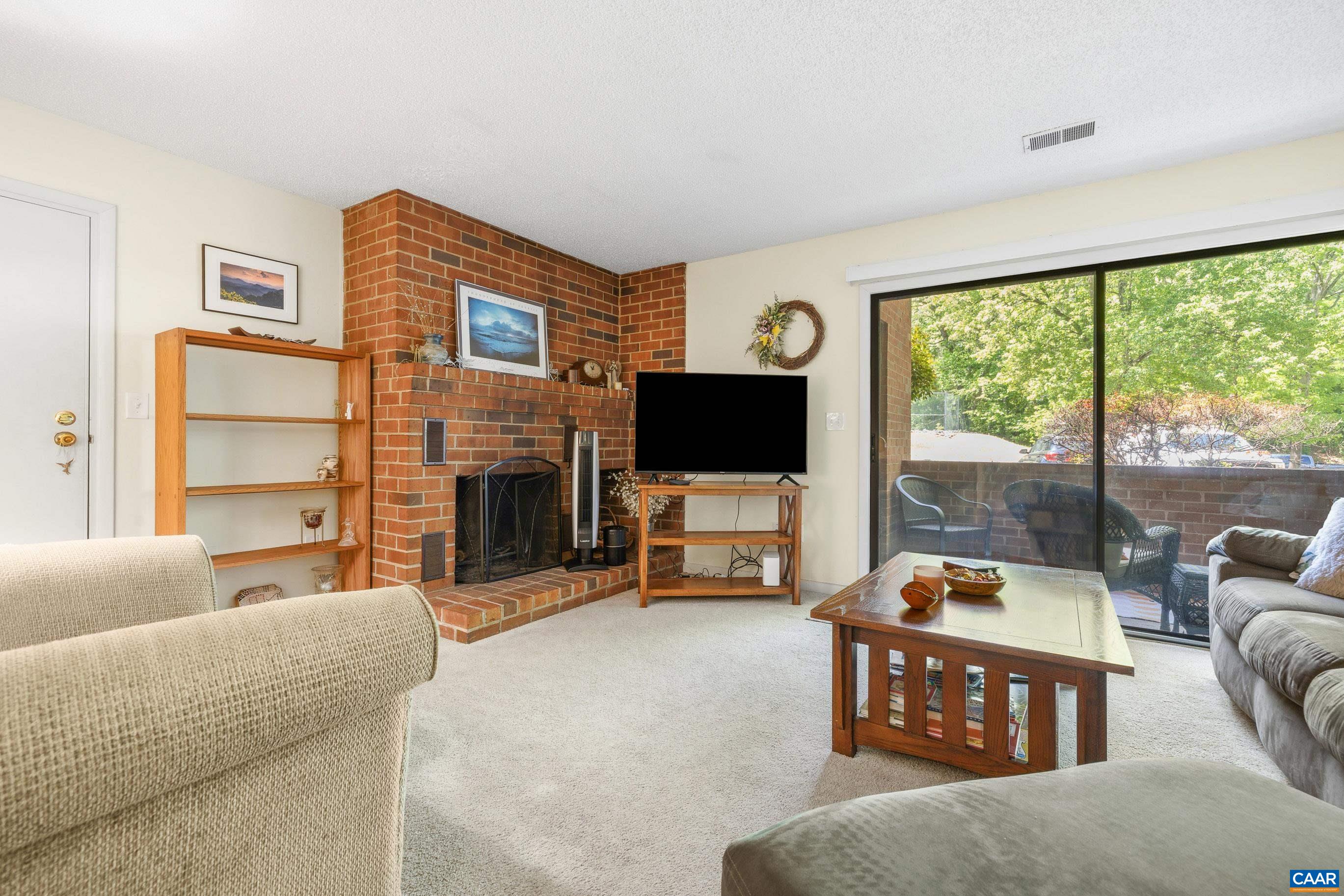 103 Turtle Creek Road, Unit 1 Charlottesville, VA 22901 - Photo 5 of 24 a living room with furniture a fireplace and a flat screen tv