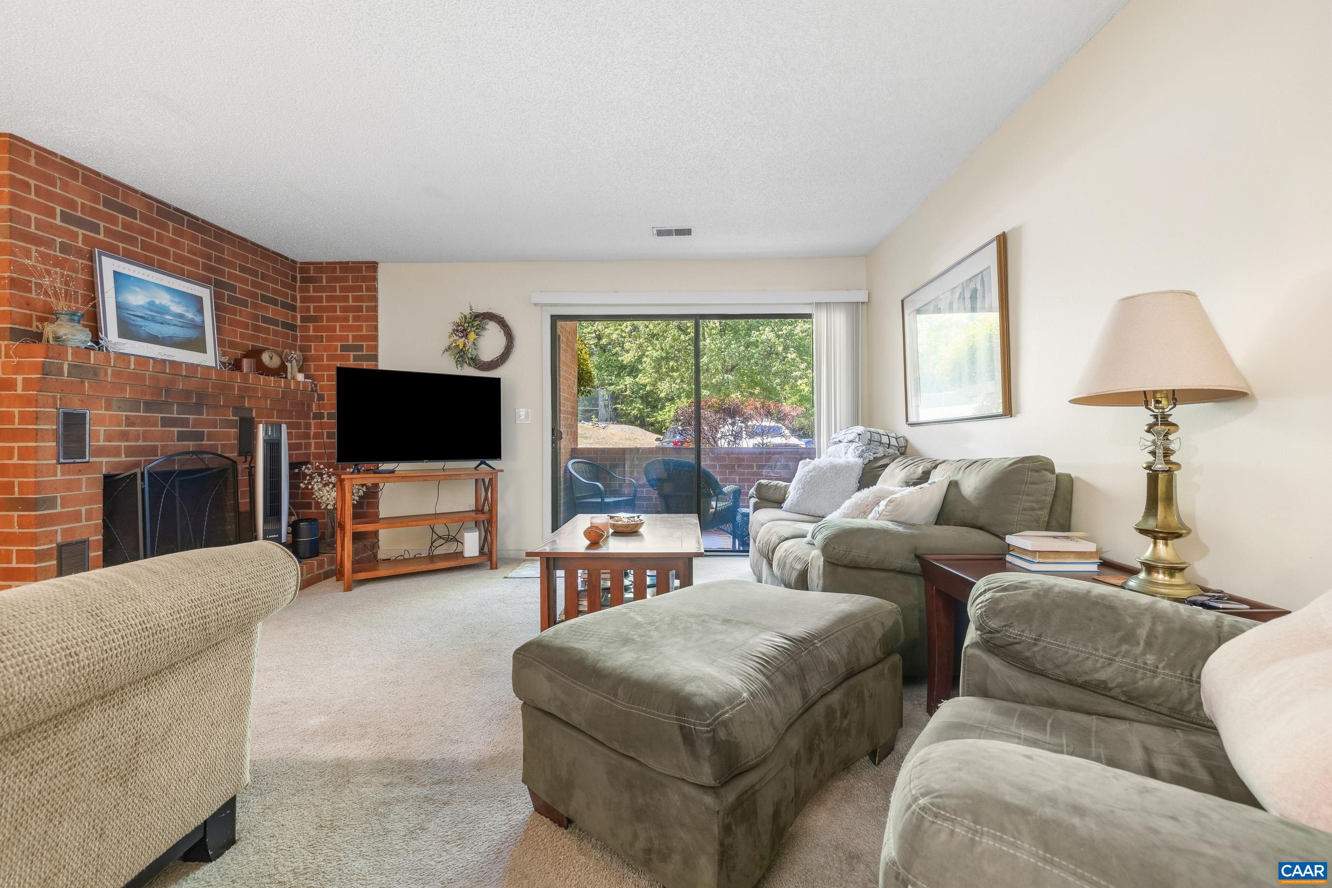 103 Turtle Creek Road, Unit 1 Charlottesville, VA 22901 - Photo 7 of 24 a living room with furniture a flat screen tv and a fireplace