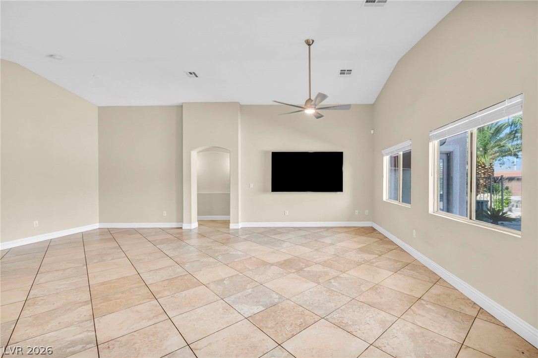6405 North Raptor Court North Las Vegas, NV 89084 - Photo 16 of 66 Natural light pours into this spacious room, highlighting the tiled flooring and vaulted ceiling.