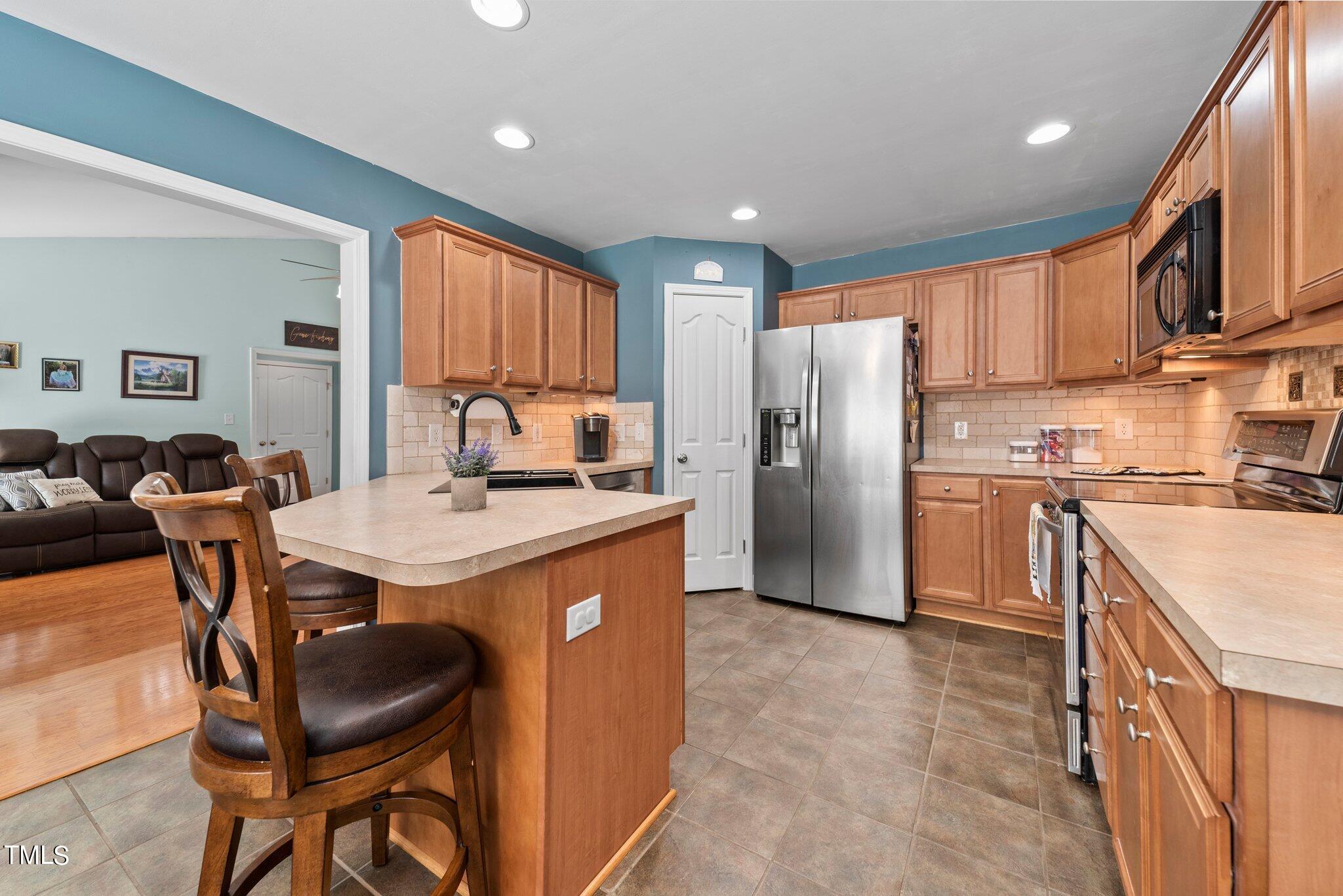 2461 Farrell Road Mebane, NC 27302 - Photo 8 of 35 a kitchen with stainless steel appliances granite countertop a table chairs and a refrigerator