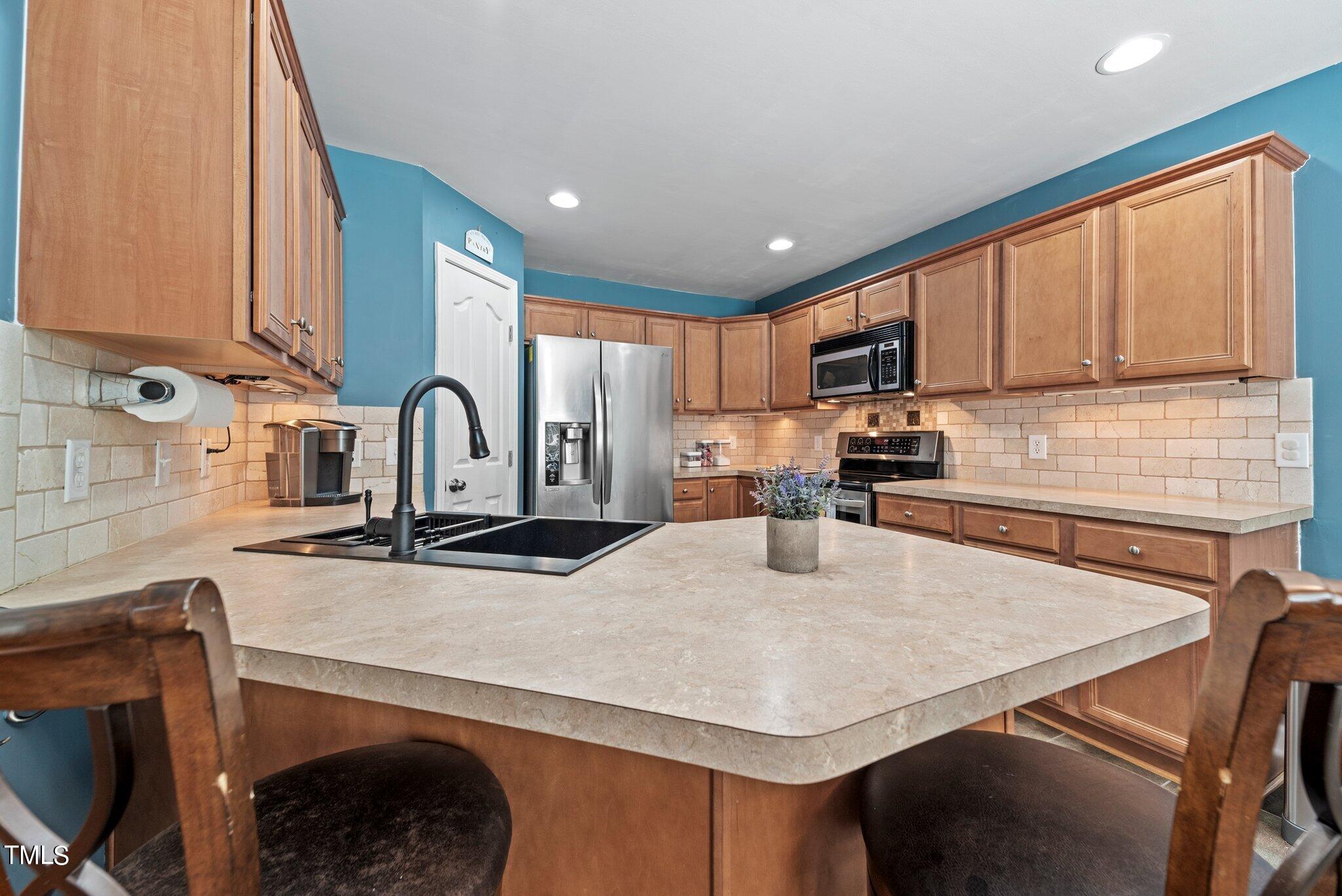 2461 Farrell Road Mebane, NC 27302 - Photo 9 of 35 a kitchen with stainless steel appliances granite countertop a sink a stove a microwave a refrigerator and cabinets