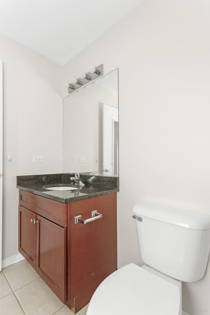 1333 West Taylor Street, Unit 2 Chicago, IL 60607 - Photo 17 of 22 a bathroom with a granite countertop toilet and a sink