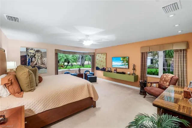 a bedroom with a bed and large windows