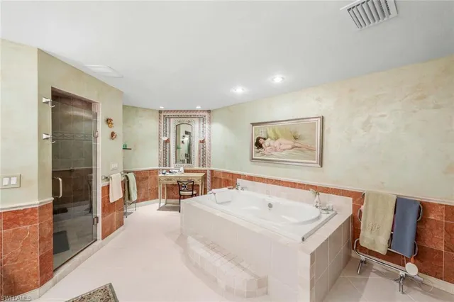 a spacious bedroom with a large bed and a chandelier