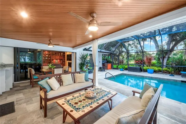 a living room with patio furniture and a large window