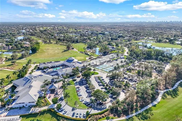 an aerial view of a city with lots of residential buildings ocean and mountain view in back