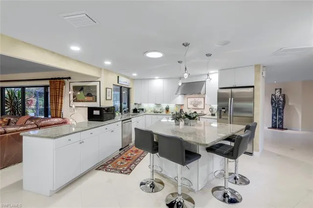 a kitchen with stainless steel appliances kitchen island granite countertop a sink and cabinets