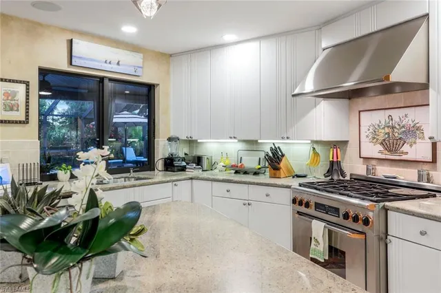 a kitchen with stainless steel appliances a stove a sink and cabinets