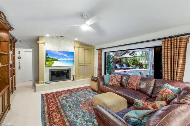 a living room with furniture fireplace and a large window