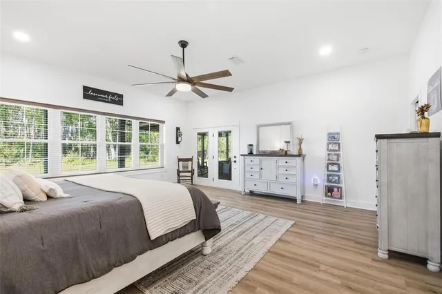 a spacious bathroom with double vanity a mirror a bathtub and a window