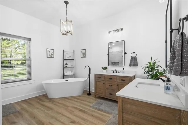 a bathroom with a double vanity sink a mirror and a bathtub