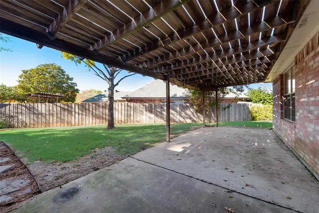 a view of a backyard with wooden fence