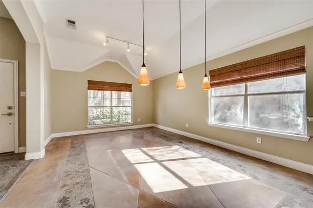 a view of an empty room with a window and doors