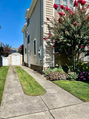 a view of a house with a small yard and a garage