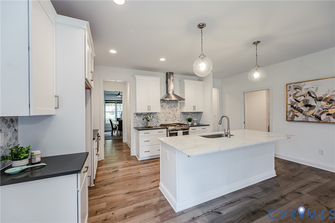 720 Chapman Street Ashland, VA 23005 - Photo 18 of 50 a large kitchen with granite countertop a stove a sink a center island and a wooden floor