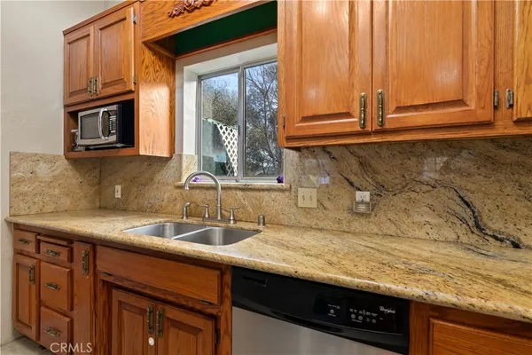 a sink with a granite countertop window and sink