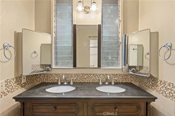 a bathroom with a granite countertop sink and a mirror