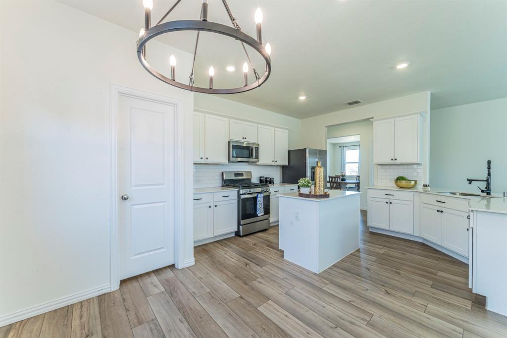1240 Almond Road Azle, TX 76020 - Photo 7 of 26 a kitchen with a refrigerator and a stove top oven