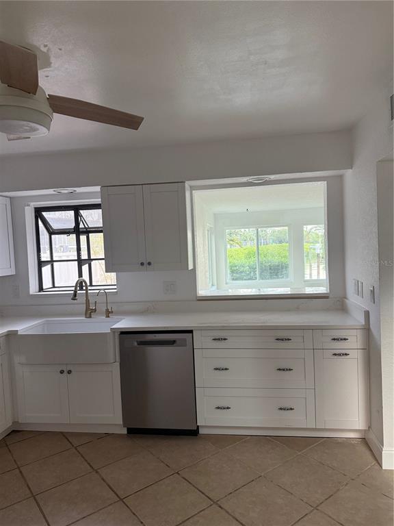 835 East Gulf Boulevard, Unit 101 Indian Rocks Beach, FL 33785 - Photo 9 of 21 a kitchen with granite countertop white cabinets and window