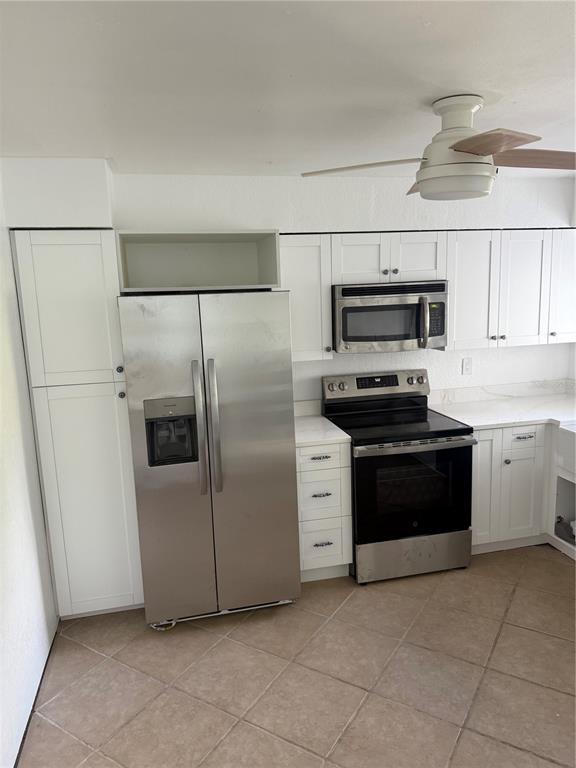835 East Gulf Boulevard, Unit 101 Indian Rocks Beach, FL 33785 - Photo 10 of 21 a kitchen with stainless steel appliances and a refrigerator