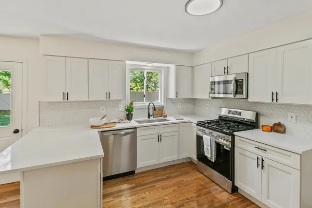 a kitchen with a stove sink and cabinets
