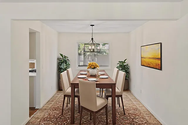 a dining room with furniture potted plants and wooden floor