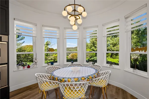 a view of a dining room with furniture a chandelier and wooden floor
