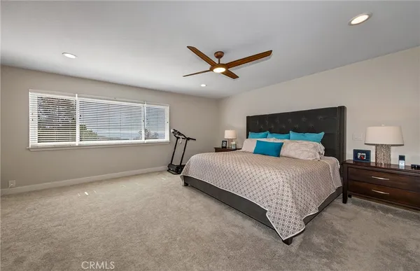 a bedroom with a large bed and two large window