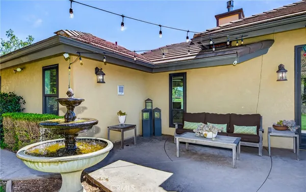 a view of a patio with table and chairs potted plants and a fountain