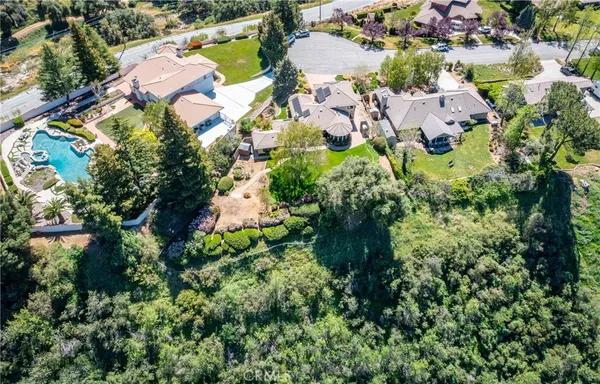 an aerial view of residential house with outdoor space and trees