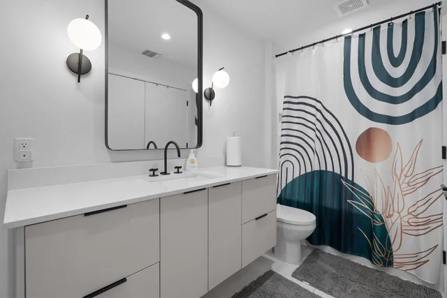 a bathroom with a sink a toilet and a mirror