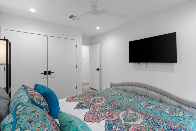 a bedroom with a bed and a flat screen tv