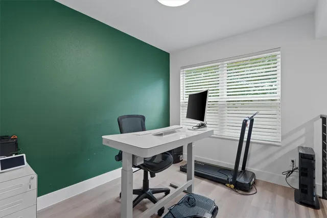 a view of a workspace with furniture and a window