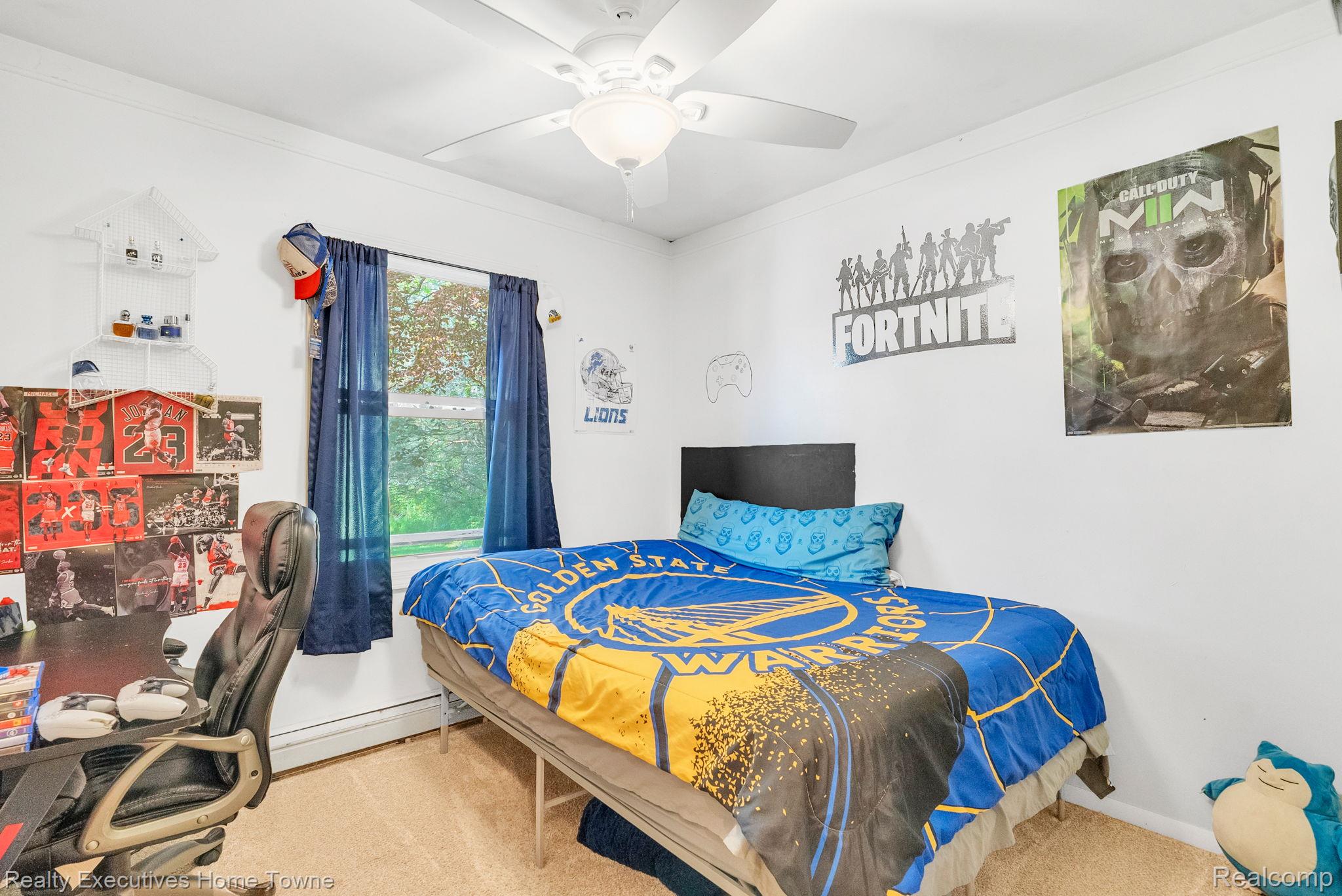 6560 Roach Road Lexington, MI 48450 - Photo 21 of 36 Bright room featuring a window with blue drapes, white walls, and light-colored carpet flooring