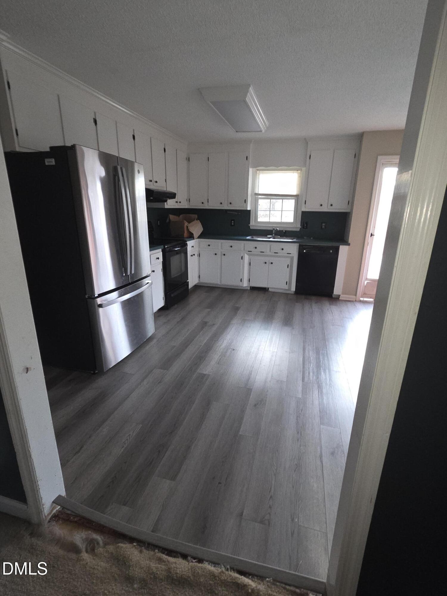727 North Orange Street Coats, NC 27521 - Photo 13 of 14 a kitchen with granite countertop refrigerator and wooden floor