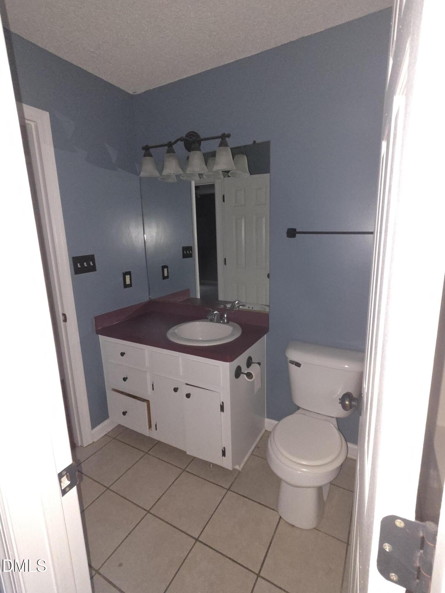 727 North Orange Street Coats, NC 27521 - Photo 5 of 14 a bathroom with a toilet sink and mirror