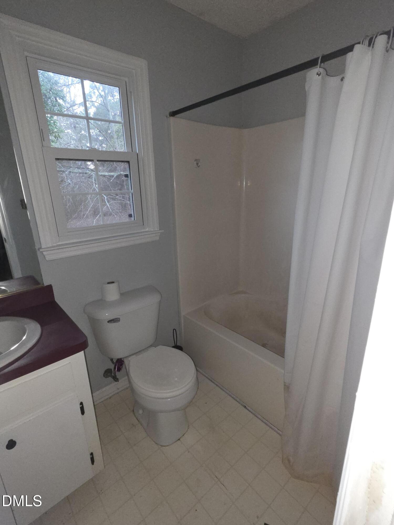727 North Orange Street Coats, NC 27521 - Photo 8 of 14 a bathroom with a shower a toilet and a sink