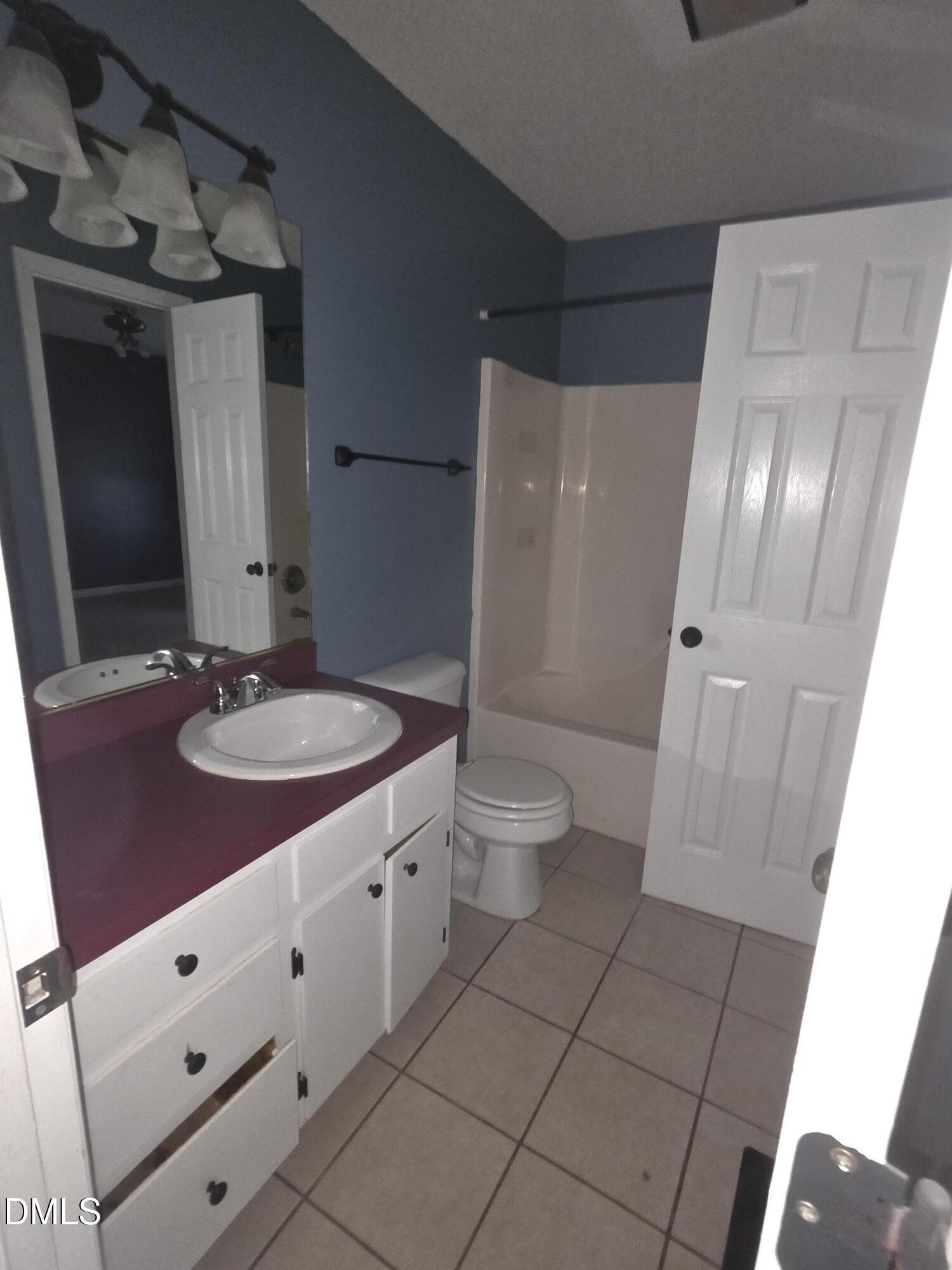 727 North Orange Street Coats, NC 27521 - Photo 10 of 14 a bathroom with a sink a toilet and shower