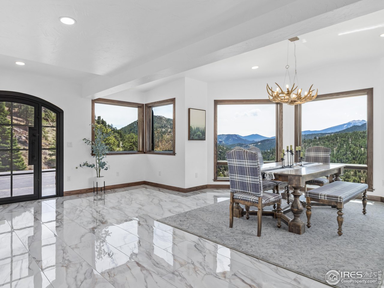 2701 Fall River Road Estes Park, CO 80517 - Photo 16 of 40 a view of a dining room with furniture large windows and a chandelier