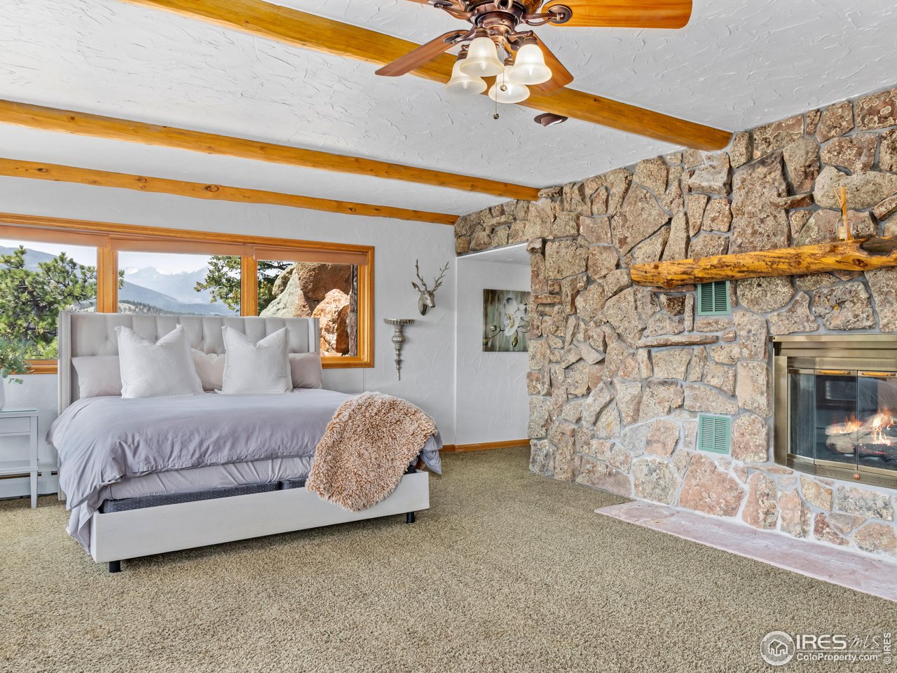 2701 Fall River Road Estes Park, CO 80517 - Photo 19 of 40 a spacious bedroom with a bed and a fireplace